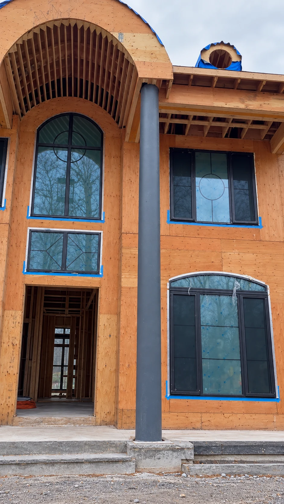 Project 2346 before exterior finishing: exposed plywood sheathing and a bare structural column